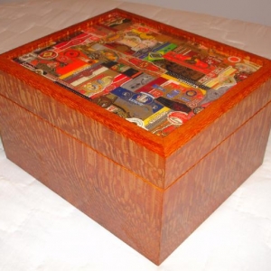 I made three desktop humidors, one for me and the others for my two best friends who live in Iowa.  This one is mine, it's made with a 1/4" thick Lacewood veneer and 1/2" Spanish Cedar interior.  The top was made of a 1/2" thick piece of MDF with cigar bands placed on one by one by my wife and I.  This was no small task!  Then a two part epoxy bar coat was used to seal the bands down.