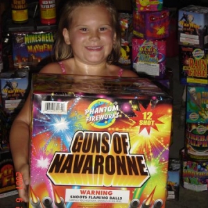 My daughter with a firework that I named.  I won a "Name that Firework" contest. At the time, Guns of Navaronne was the largest Consumer Class firework in production.  

It's as big as a small child!!!