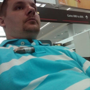 Me waiting for a flight at Denver air port with gar in shirt.