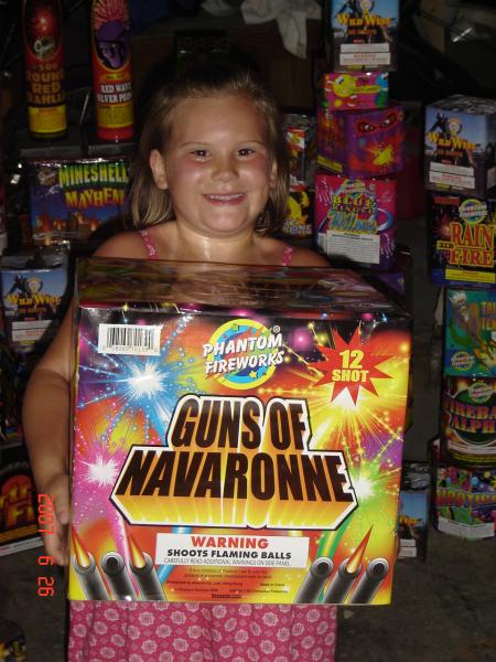 My daughter with a firework that I named.  I won a "Name that Firework" contest. At the time, Guns of Navaronne was the largest Consumer Class firework in production.  

It's as big as a small child!!!